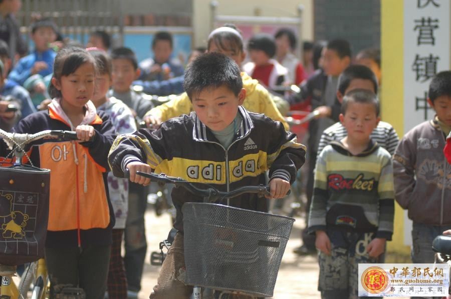 新华社照片，聊城（山东），2012年4月30日　　山东聊城男孩白广春9岁撑起一个家　　放学后，白广春（中）骑 ...