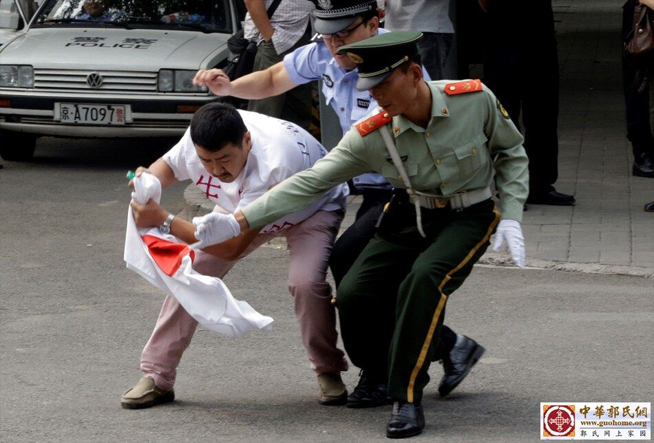 2012年9月11日，北京，日本驻华使馆外，安保人员试图阻止一名欲焚烧日本国旗的男子。2.jpg