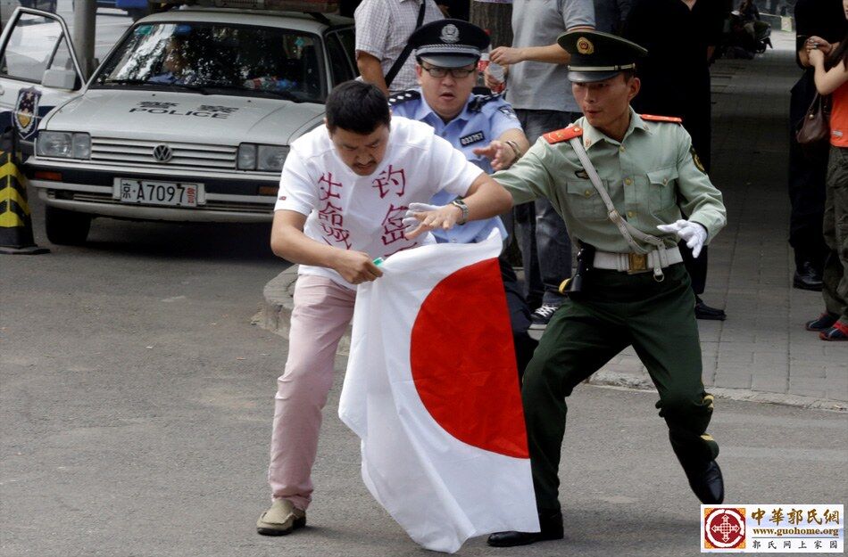 2012年9月11日，北京，日本驻华使馆外，安保人员试图阻止一名欲焚烧日本国旗的男子。.jpg